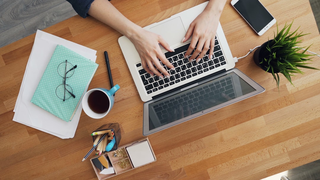 Female hands typing using laptop computer in office communicating at work